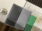Small bag with dark gray leather exterior and smooth gray interior panels, stitched edges.
