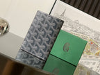 Small bag with dark gray monogram canvas front and black trim, shown in upright view.