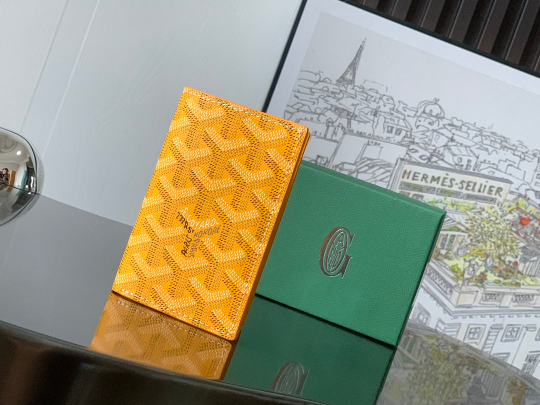 Orange patterned Goyard bag with green panel and snap front