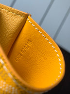 Yellow leather small bag with embossed text and white contrast stitching