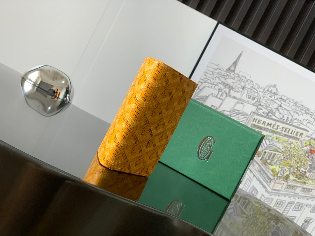 Yellow patterned small bag with front closure and green panel, side view