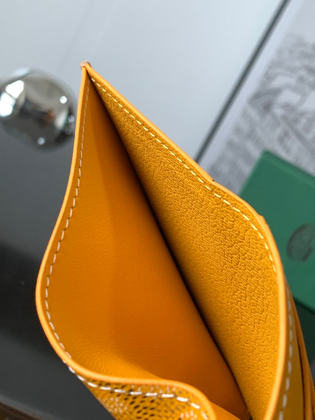 Orange leather Goyard bag corner with white contrast stitching