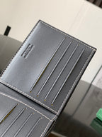 Small cardholder-style bag with stitched dark leather panel and four thin metal rods