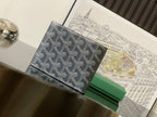 Small patterned bag with dark canvas, front flap, and stitched leather edge