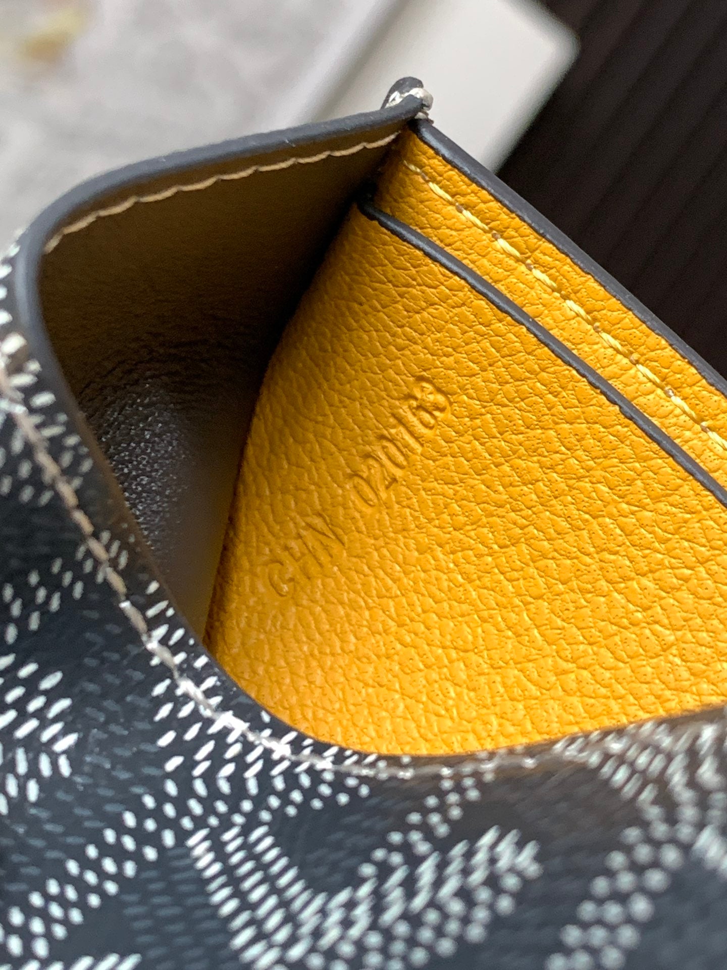 Small bag interior with bright yellow leather lining and dark patterned outer edge