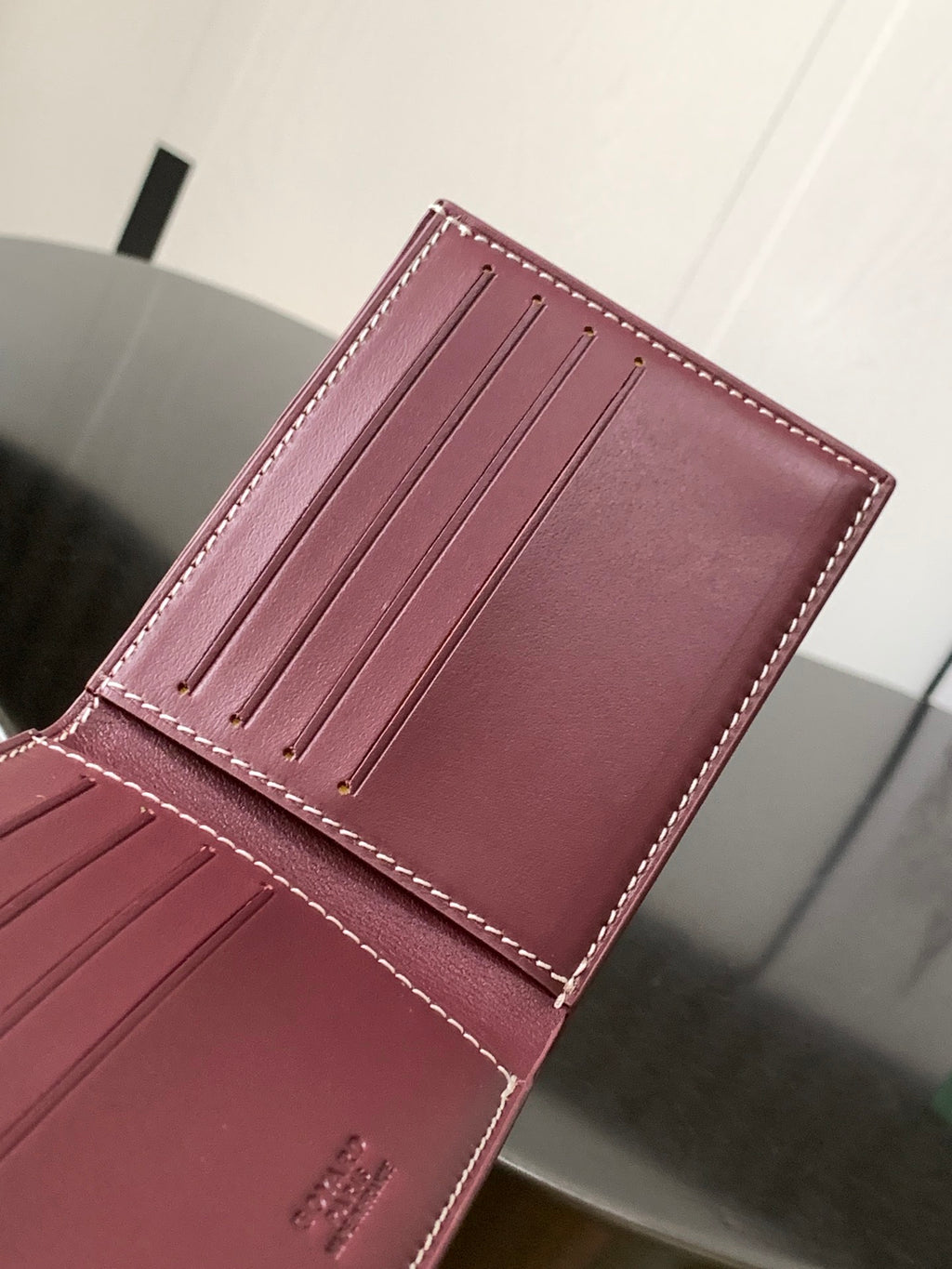 Burgundy small bag front view with card slots and visible stitched detailing.