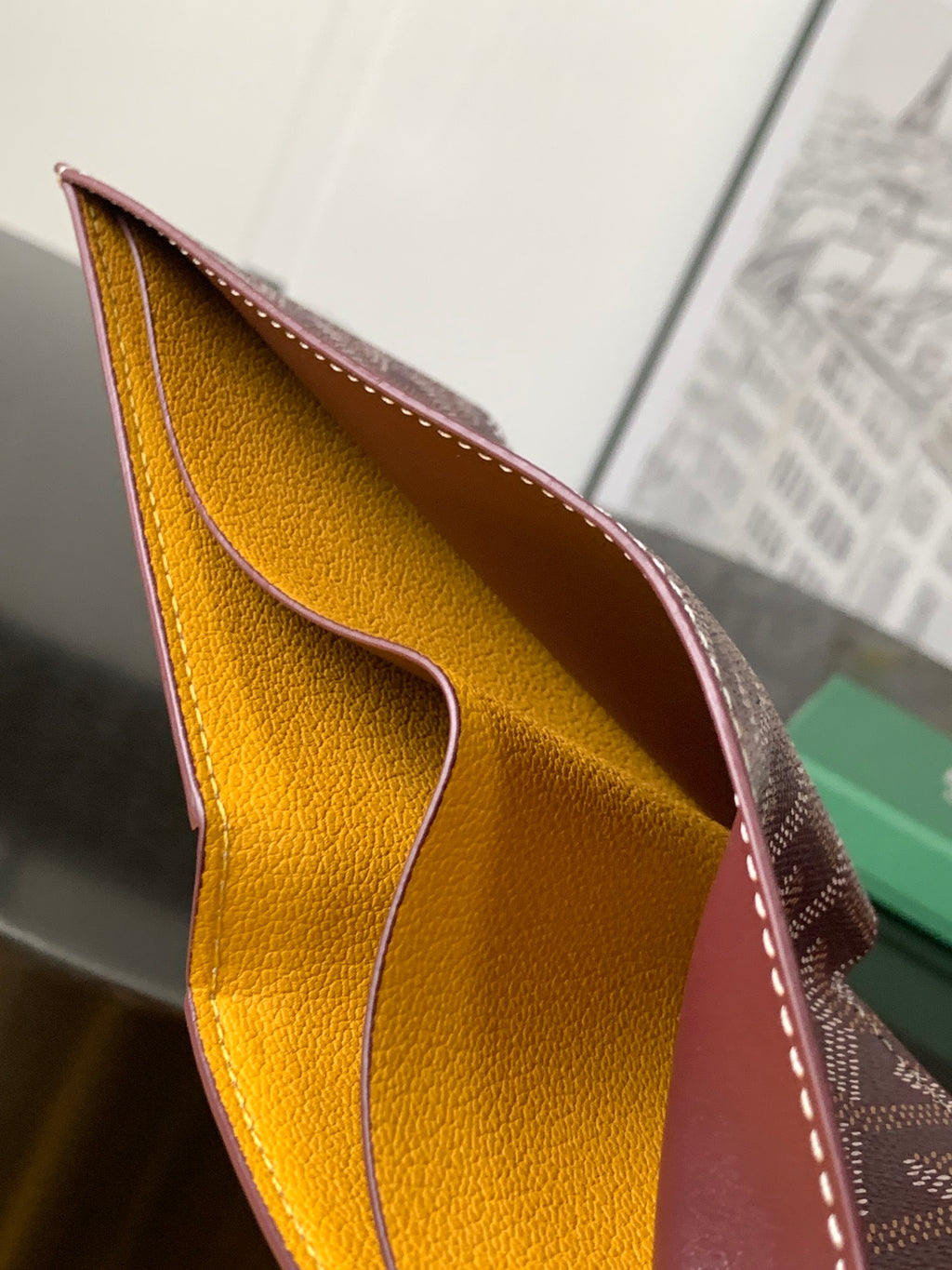 Burgundy small bag open view showing mustard-yellow leather interior lining.