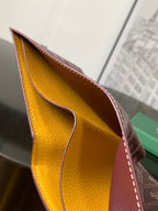 Burgundy small bag open view showing mustard-yellow leather interior lining.