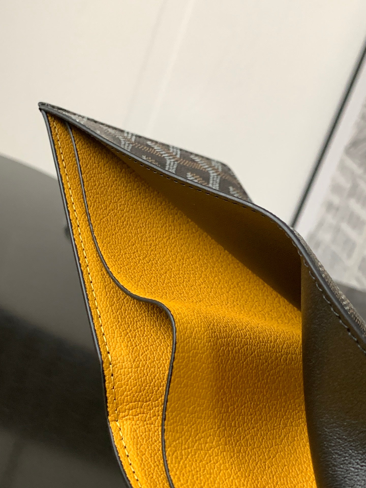 Small bag interior lining in bright yellow leather with curved seam