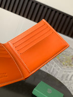 Orange Goyard card holder wallet open, showing card slots and stitched edge.
