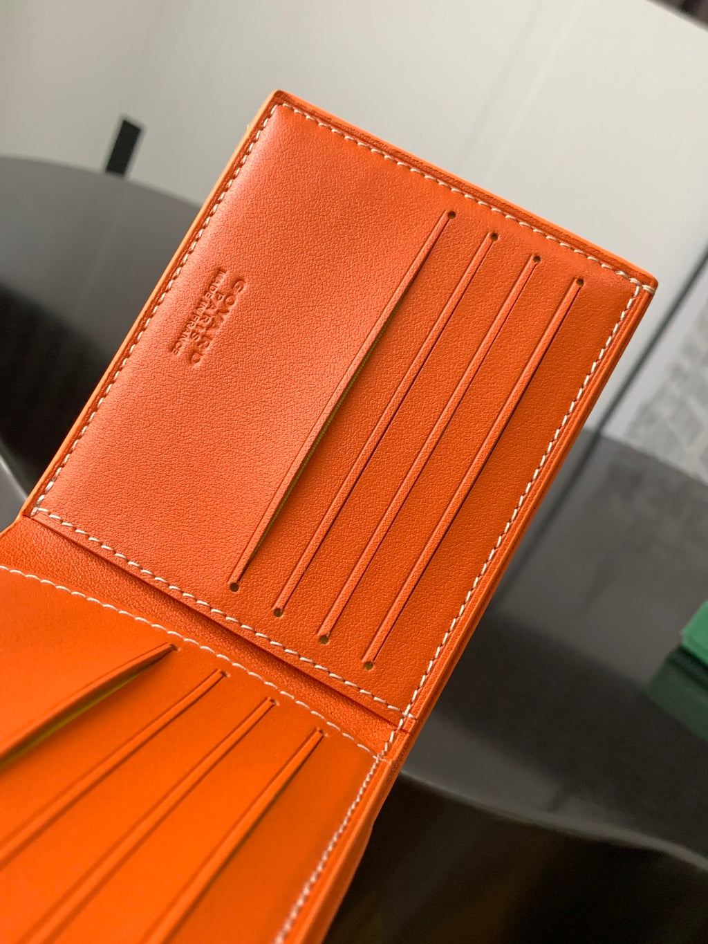 Orange Goyard card holder wallet with front panel and 5 vertical card slots.