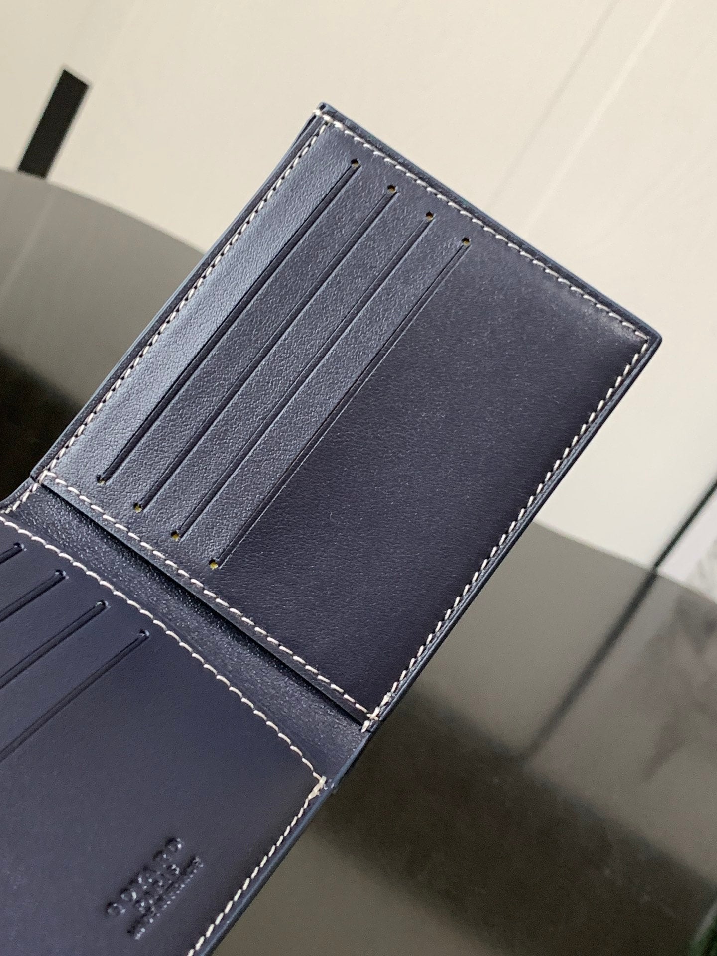 Goyard bag open, showing blue card slots with dashed trim stitching