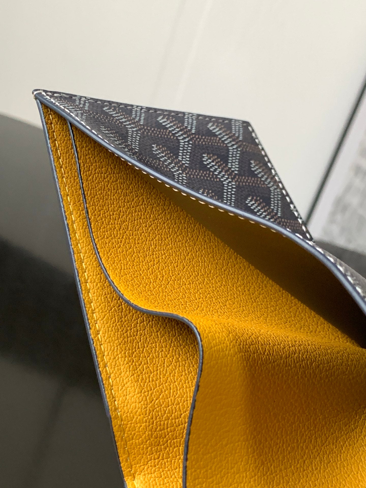 Small bag with navy patterned exterior and warm yellow interior lining