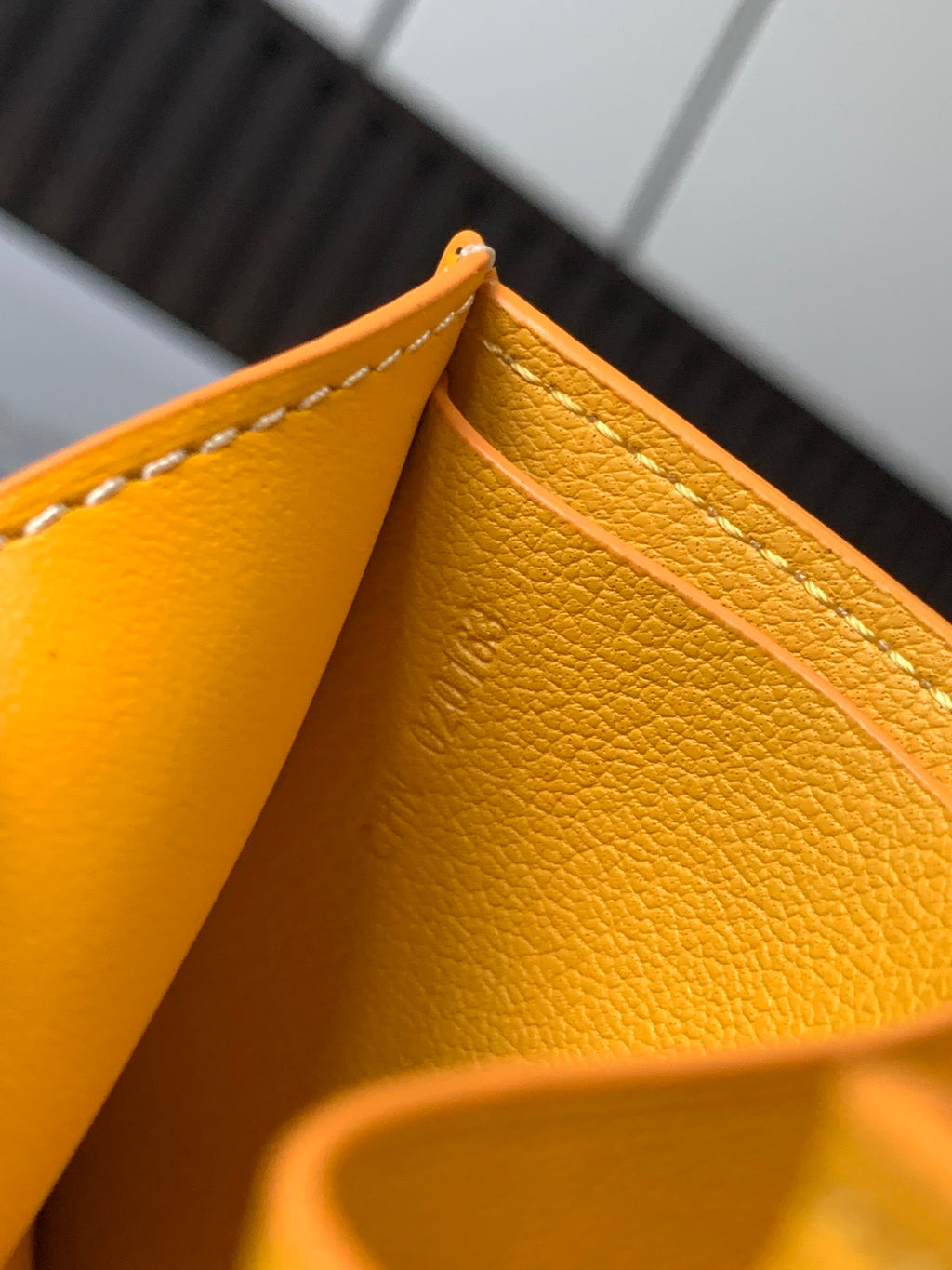 Goyard small bag, close-up of yellow leather interior seam and edge