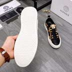 White outsole of black-and-gold sneakers shown in hand