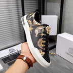 Black sneaker on hand, gold and animal graphic embroidery, lace-up with eyelets