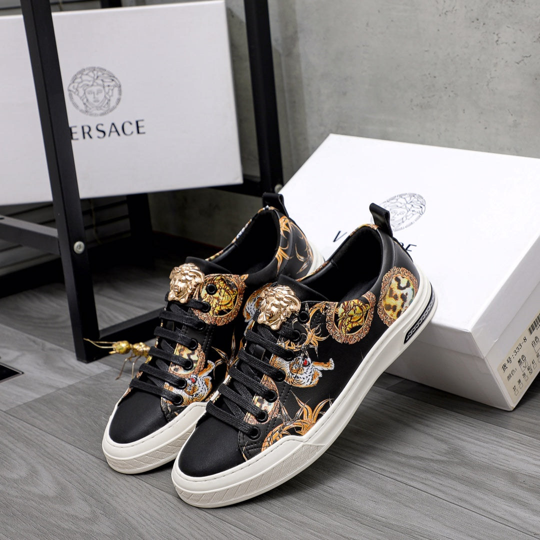 Pair of black low-top sneakers with gold baroque animal motifs and white soles