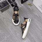 Black and gold low-top sneakers with animal print uppers and white rubber sole