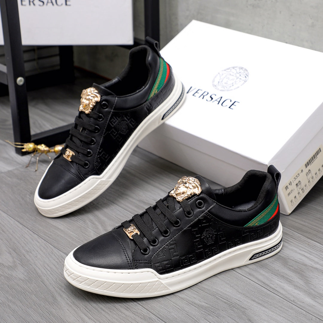 Versace black low-top sneakers with gold crest hardware, green/red stripe, and white sole
