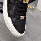 Versace black low-top sneaker close-up, black laces and gold crest lace hardware