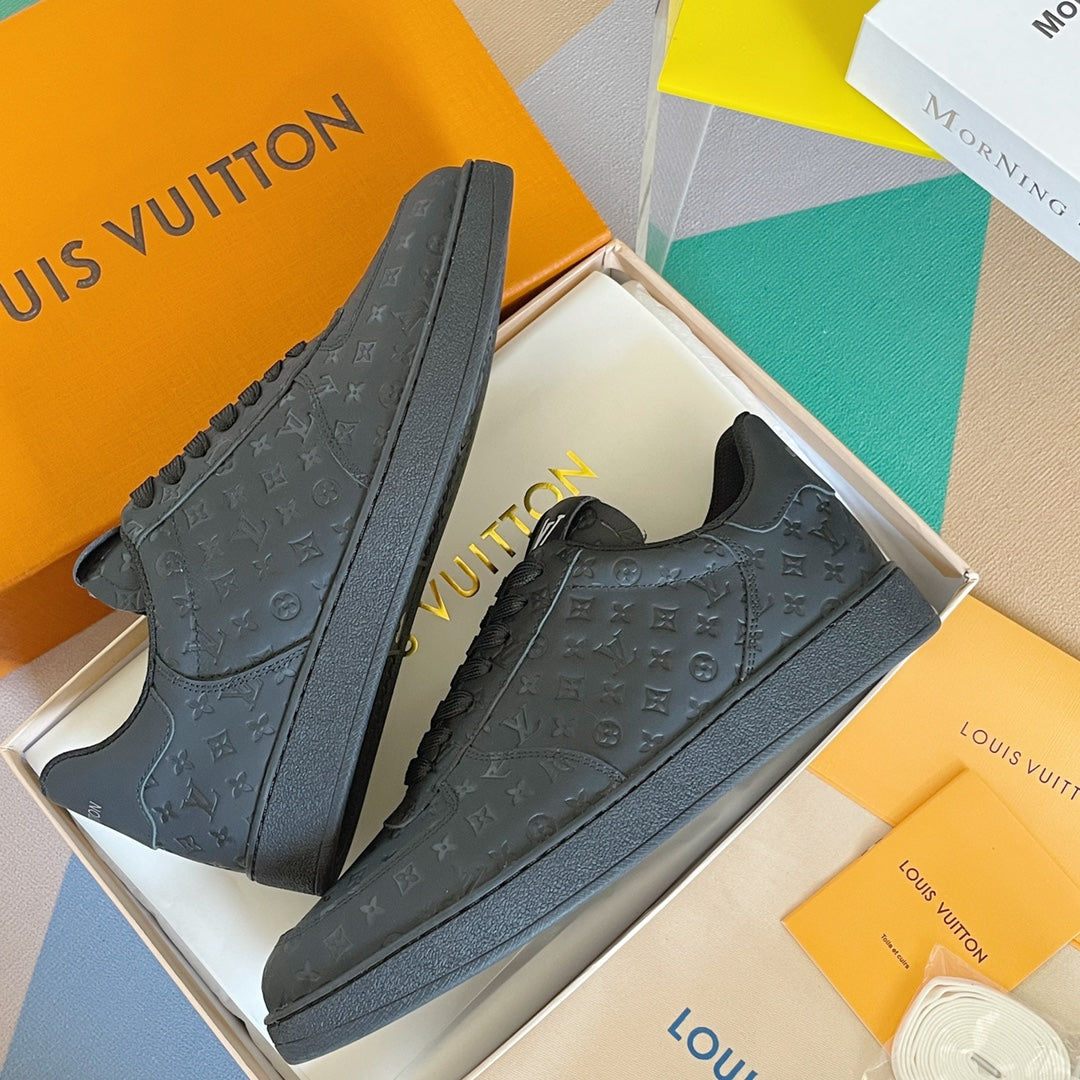 Louis Vuitton dark monogram low-top sneakers, angled side view with lace-up vamp.