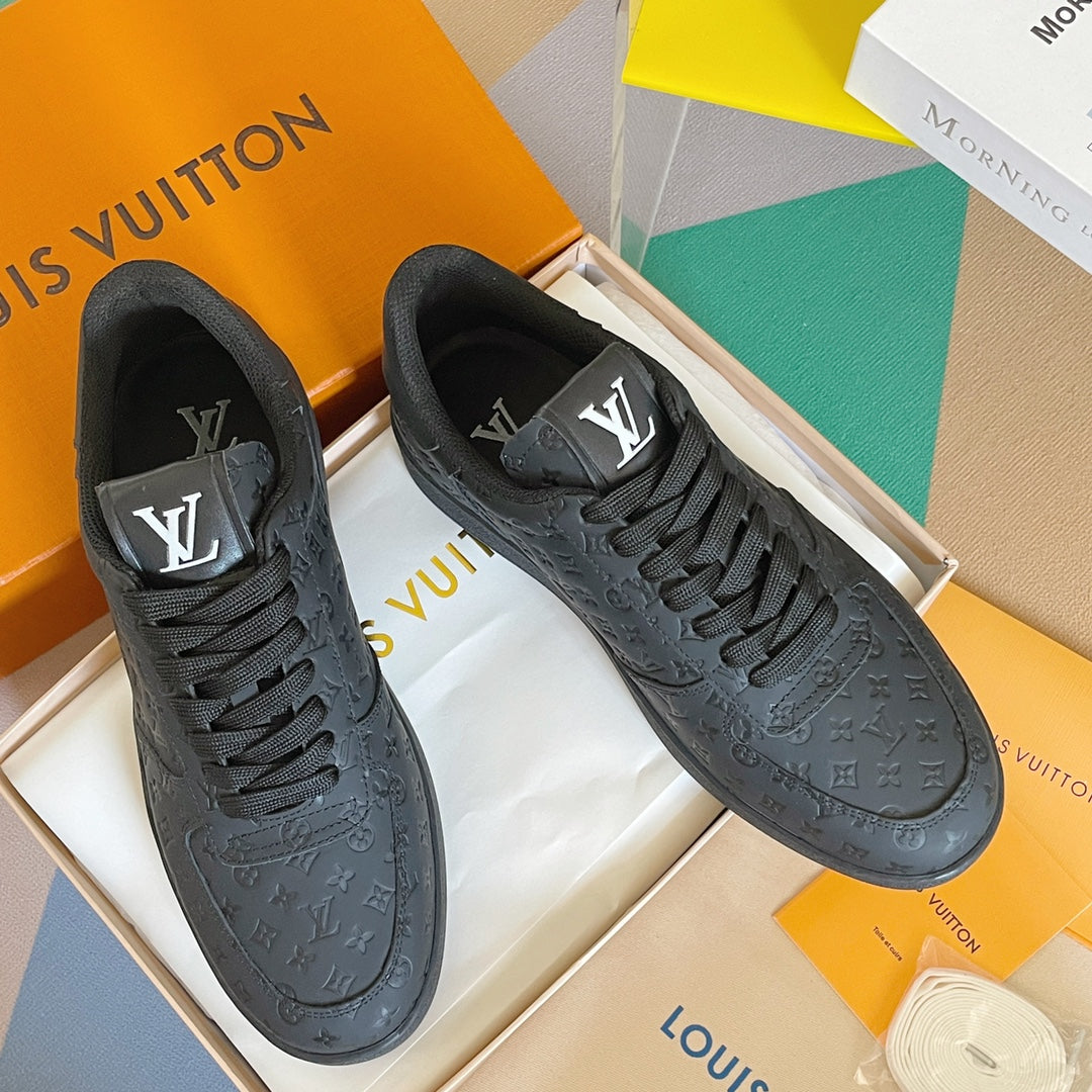 Louis Vuitton low-top lace-up sneakers with dark embossed monogram pattern.