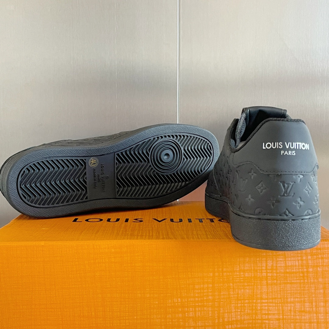 Louis Vuitton dark monogram sneakers with textured rubber outsole and heel.