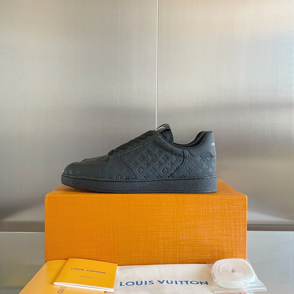 Louis Vuitton dark low-top sneakers with embossed monogram and lace-up closure.