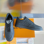 Louis Vuitton dark monogram low-top sneakers, lace-up style with embossed details.
