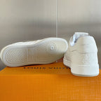 White sneakers with rubber outsole tread and embossed LV logo on heel.