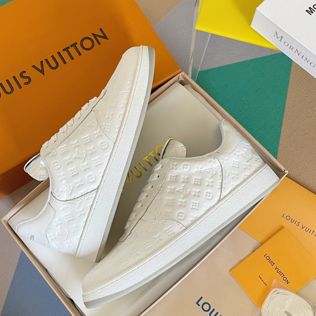 White LV monogram sneakers with lace-up front and cushioned collar.