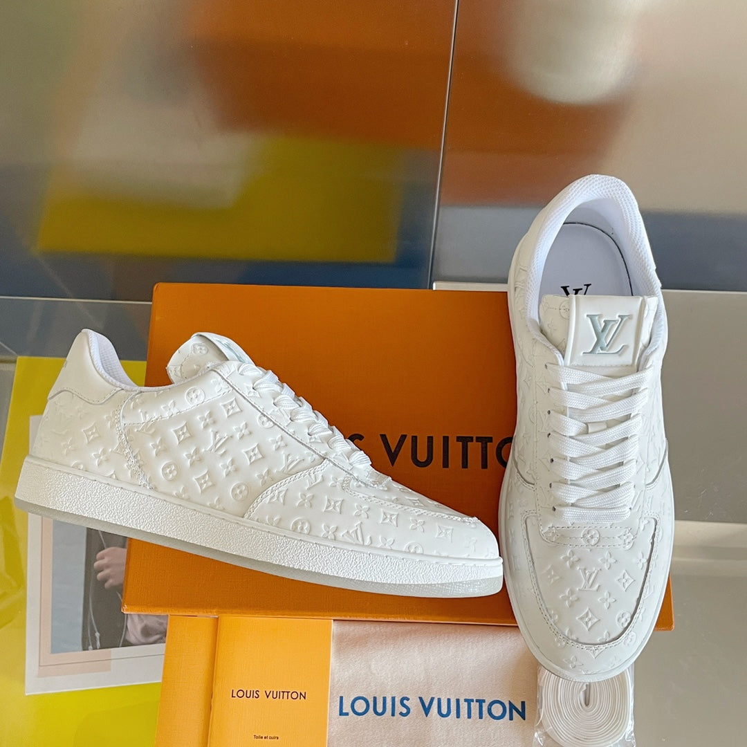 White lace-up sneakers with embossed LV monogram details and logo on heel.