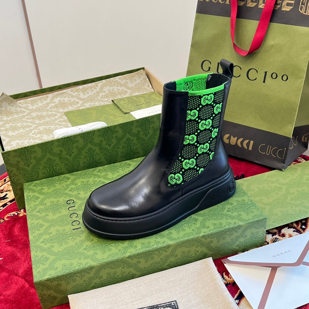 Black Chelsea boots with neon green GG-pattern elastic, low heel styling.