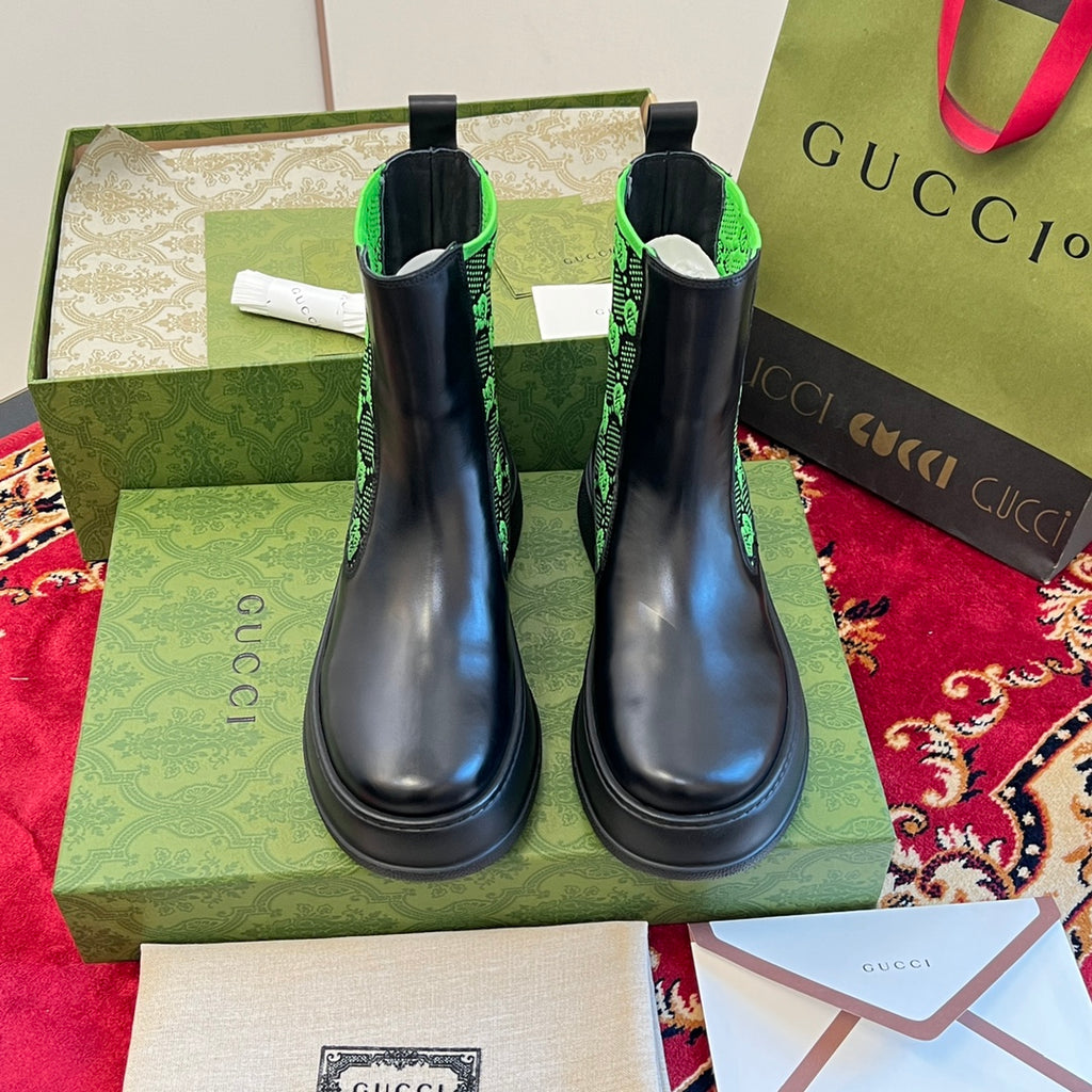 Black Chelsea boots with neon green GG-pattern ankle panels, side view.