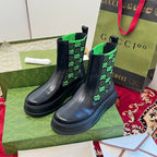 Black Chelsea boots with neon green GG-pattern elastic panels.