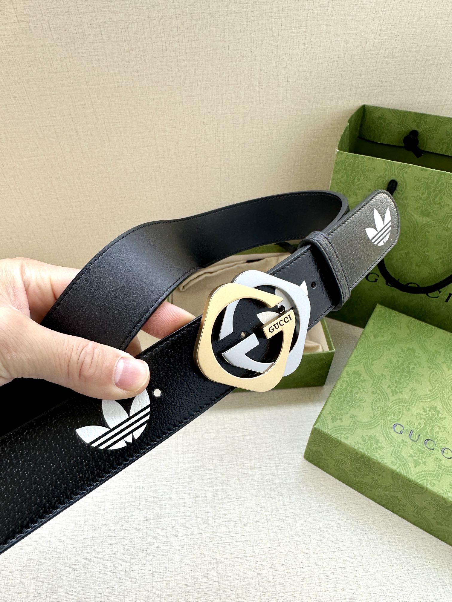 Gucci belt showing round logo buckle and white trefoil pattern on dark navy strap