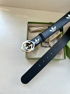 Gucci belt with dark navy strap, white trefoil logos, and round buckle on box display