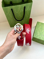 Red Gucci belt with white trefoil print and close-up of circular logo buckle
