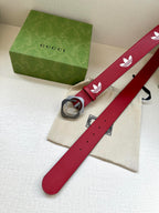 Red Gucci belt with white trefoil print and silver-tone buckle, flat view