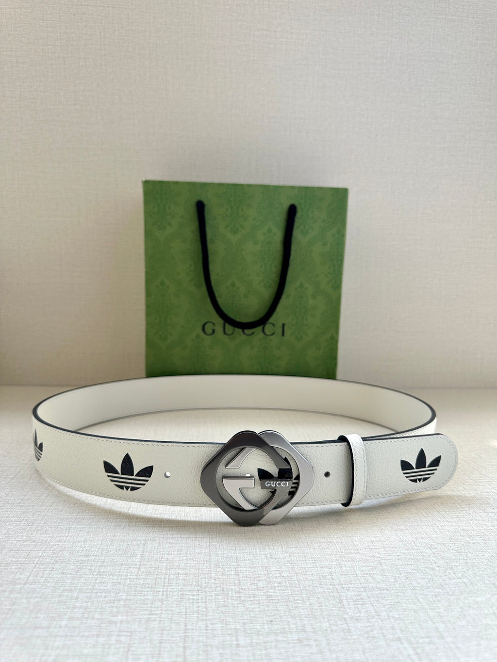 Gucci belt in white leather with black logo print and round grey buckle centerpiece