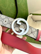 Gucci GG canvas belt, silver G buckle close-up with red leather strap