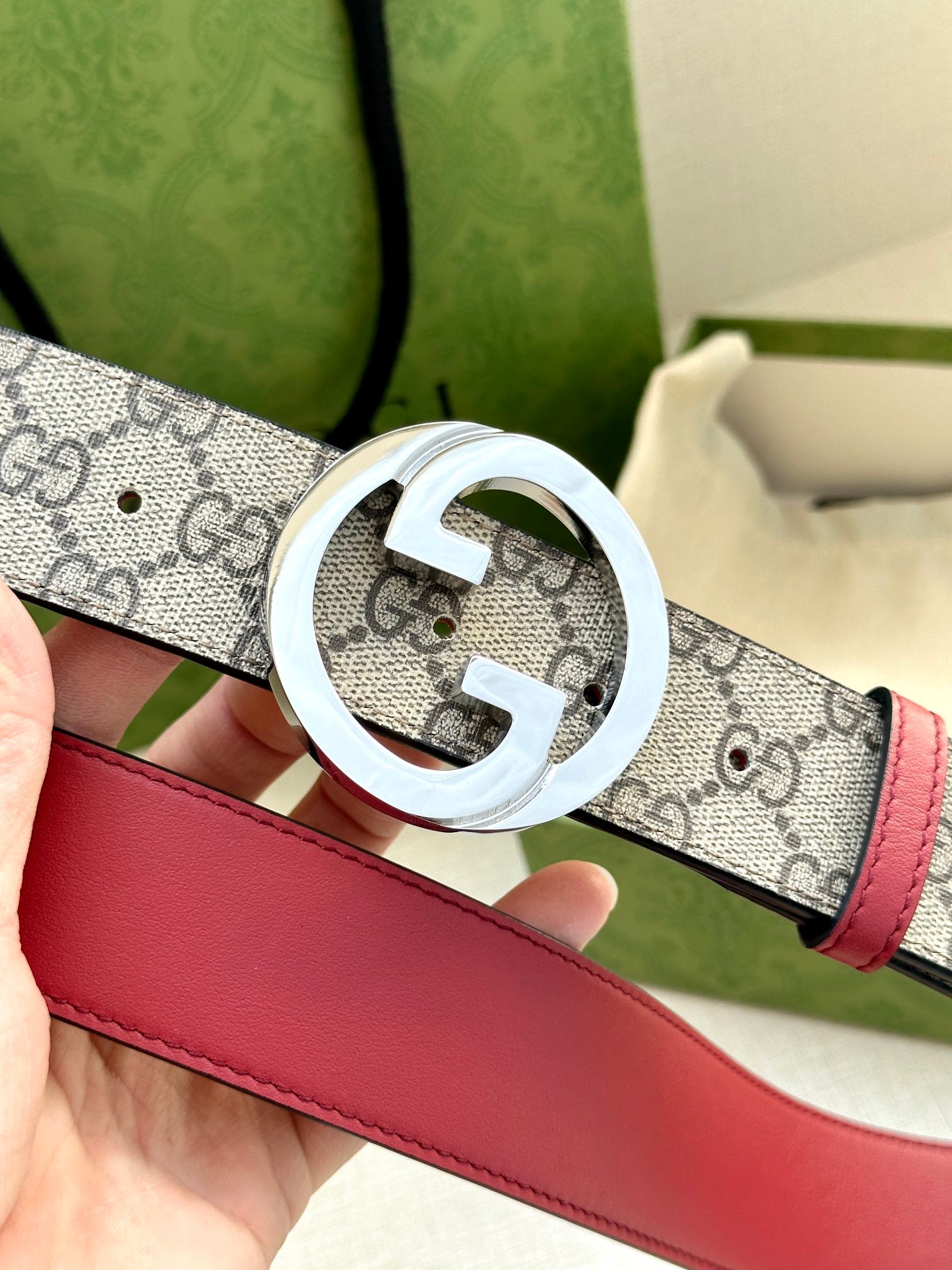 Gucci GG canvas belt, silver G buckle close-up with red leather strap
