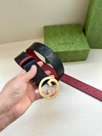 Gucci belt on hand: dark monogram leather with gold-toned G buckle and red underside.