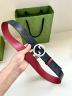 Gucci belt in hand: dark monogram strap with gold-toned G buckle and red underside trim.