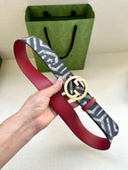 Gucci belt with navy monogram webbing, red leather strap, gold-tone GG buckle.