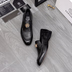 Black leather loafers with gold lion emblem on vamp, side view pair