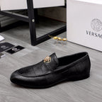 Black leather loafer with gold emblem at vamp and slip-on silhouette