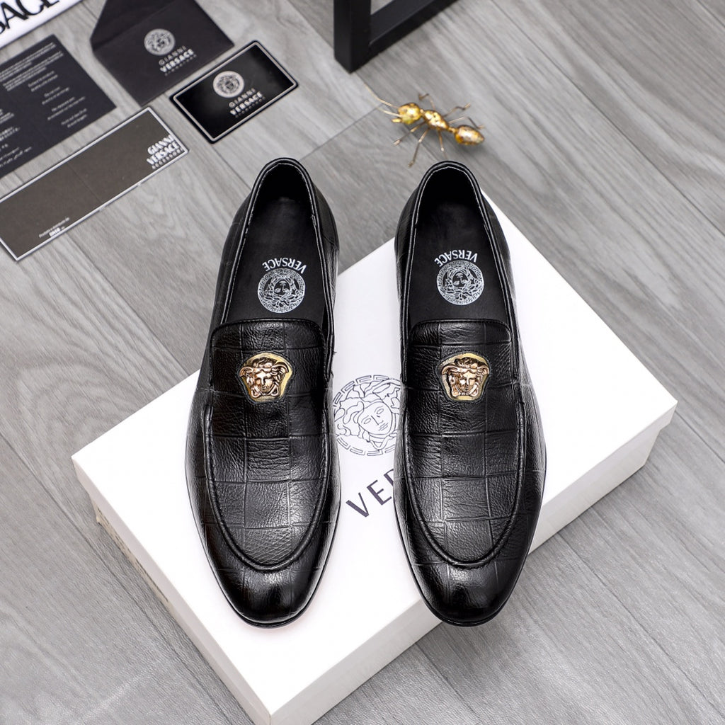 Black leather loafer with gold lion emblem and moc-style stitching