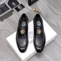 Black leather loafer with gold lion emblem and moc-style stitching