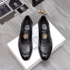Black leather loafer with gold lion emblem and moc-style stitching